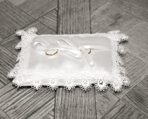 Wedding rings on a laced cushion