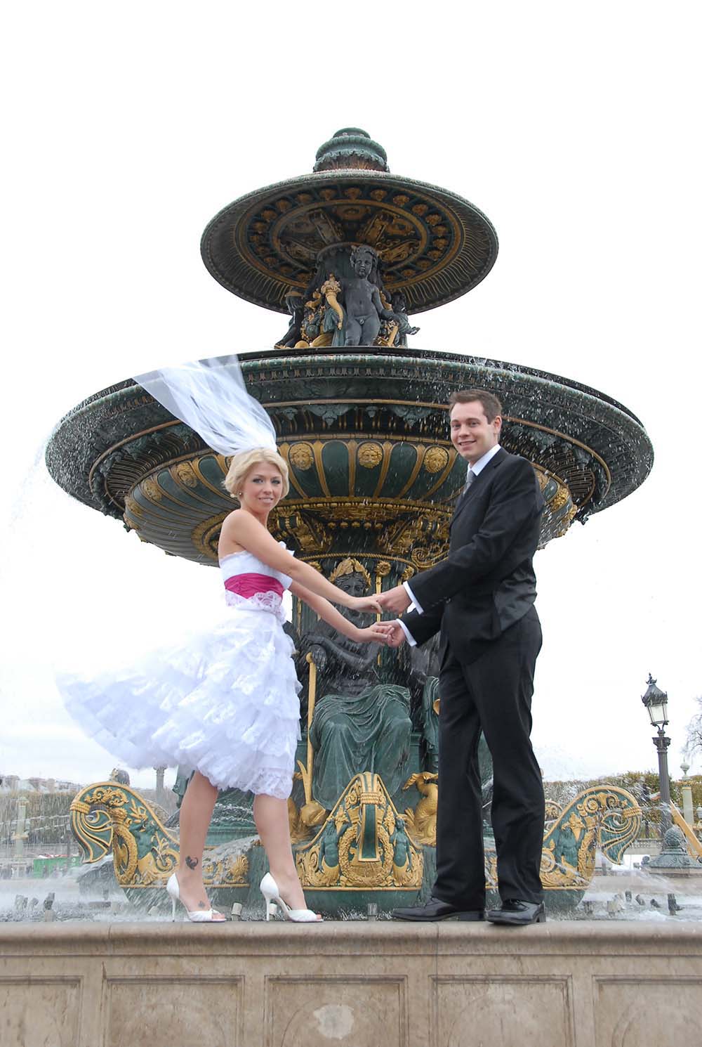 Wedding couple standing on Concorde Fountain, Paris, France